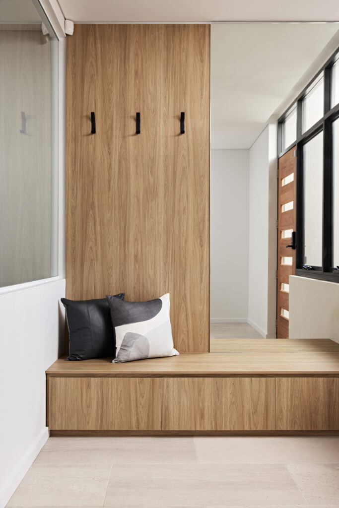Timber entry bench with coat hooks and cushions